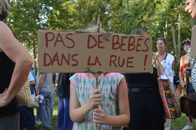 Julie porte fièrement sa pancarte pendant le rassemblement du 31 juillet devant la Métropole de Lyon (Lyon 3e). Du haut de ses 7 ans, elle se sent à la fois "triste et en colère" de savoir que d'autres enfants dorment dans la rue.